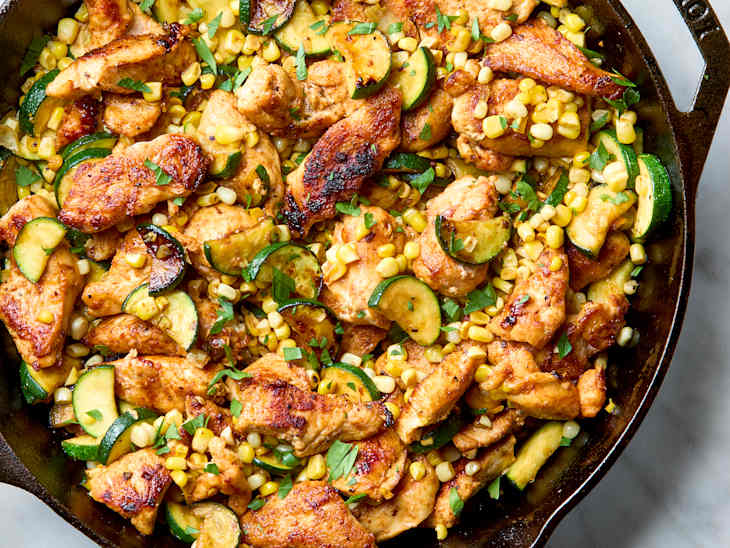 overhead shot of skillet chicken with corn and zucchini.