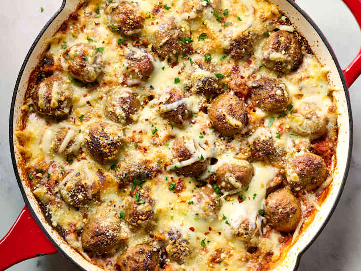 Meatballs and rice casserole in a red cast iron skillet