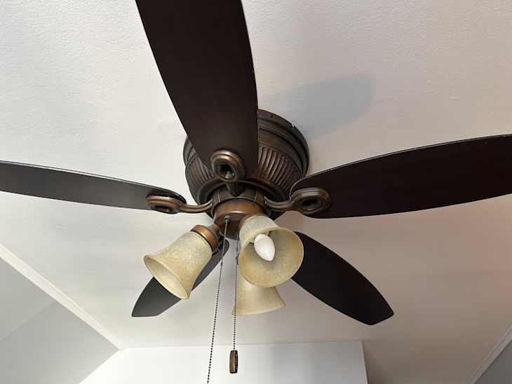 Using pillow case to dust ceiling fan.