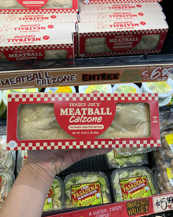 Someone holding Trader Joe's Meatball Calzone package.