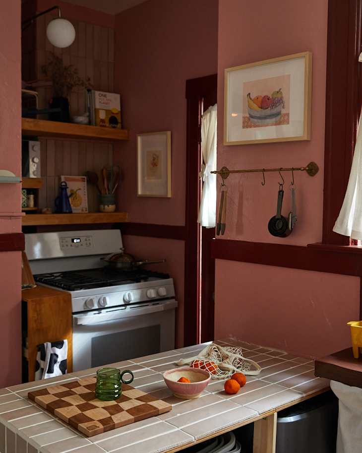 Artwork on wall in pink painted kitchen.