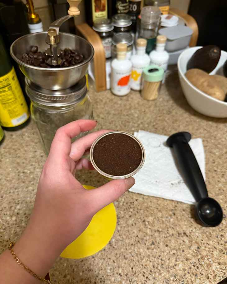 Someone holding portafilter with ground espresso.