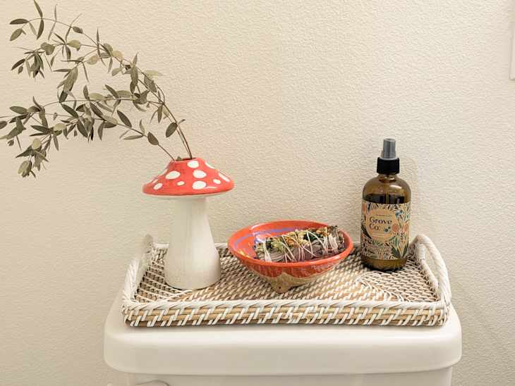 Eucalyptus in vase on bathroom tray.