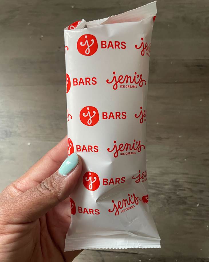 Someone holding passion fruit dreamsicle ice cream in package.