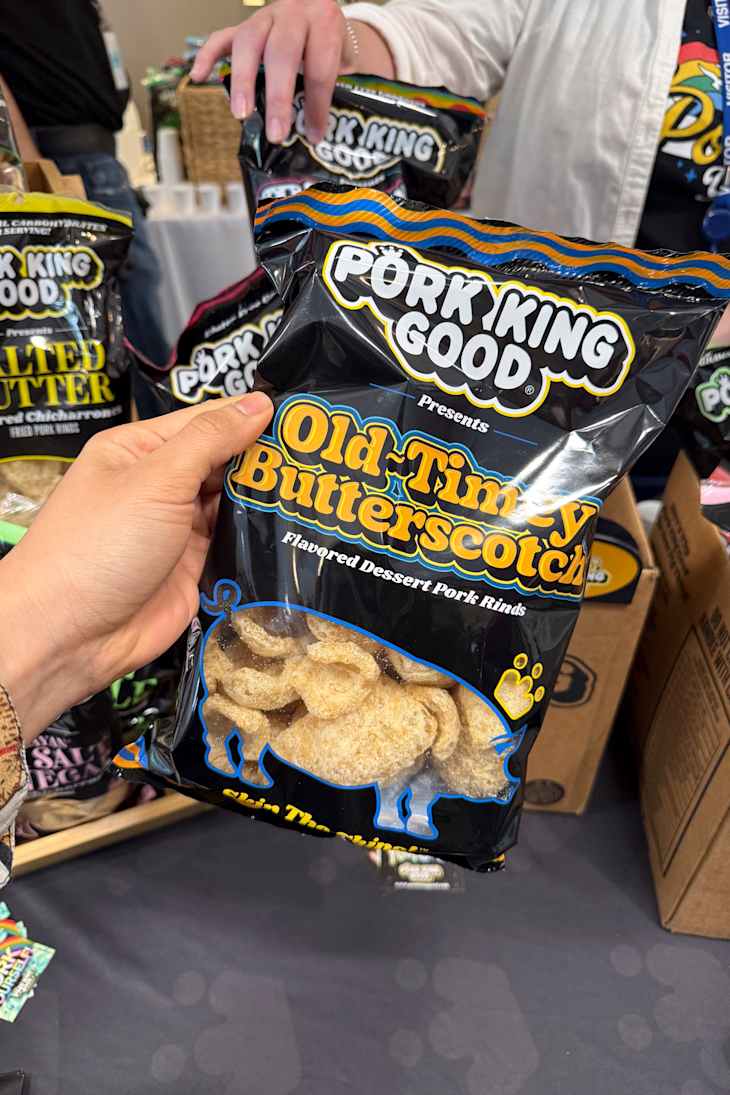 A hand holding a bag of Old-Timey Butterscotch flavored pork rinds.