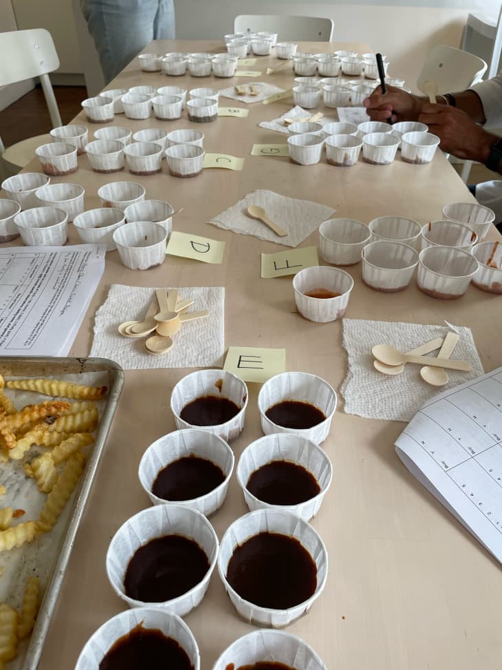 Paper ramekins of barbecue sauce on table.