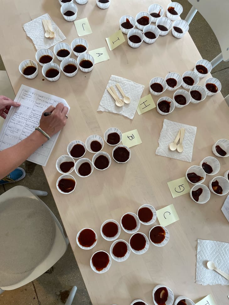 Paper ramekin of barbecue sauce on a table.