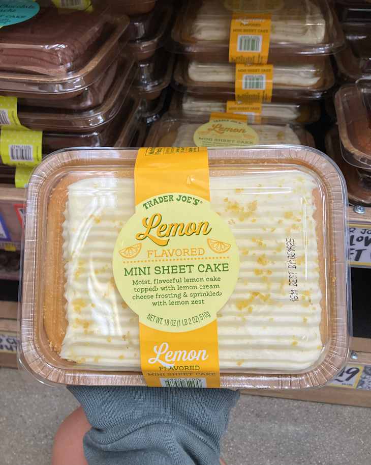 Someone holding Trader Joe's Lemon sheet cake.