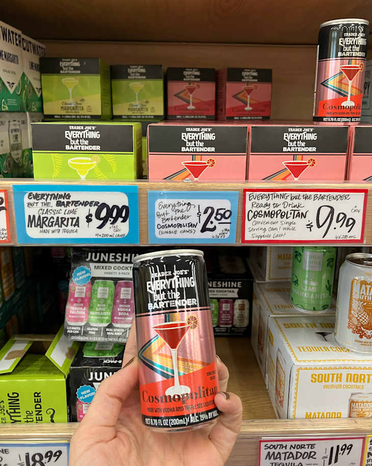 Someone holding Trader Joe's canned Cosmopolitan cocktail.