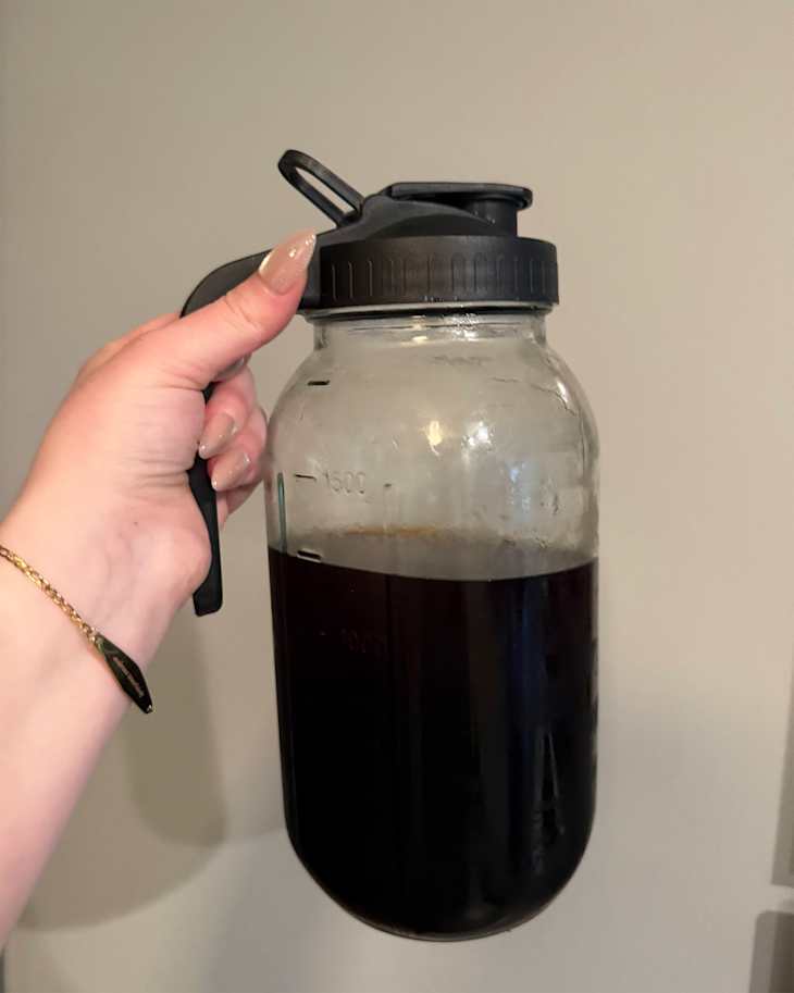 Someone holding cold brew mason jar.