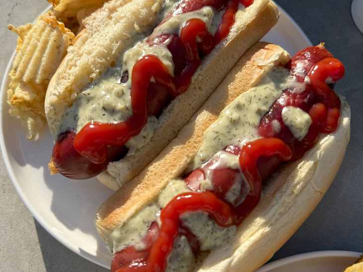Hot dogs with ketchup and Ayoh Mayo Dill Pickle Sando Sauce and potato chips.