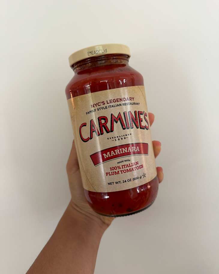 Someone holding a bottle of Carmine's marinara sauce.