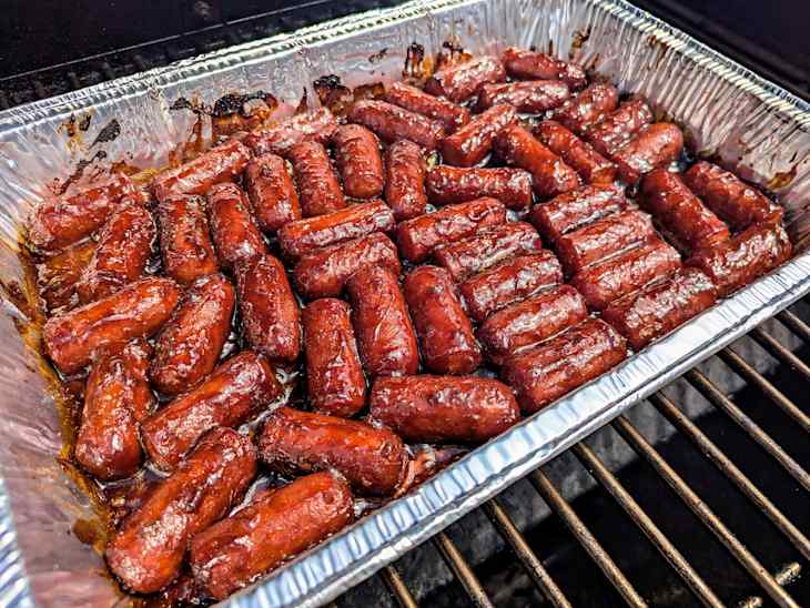 burnt hot dog ends in aluminum baking pan in oven