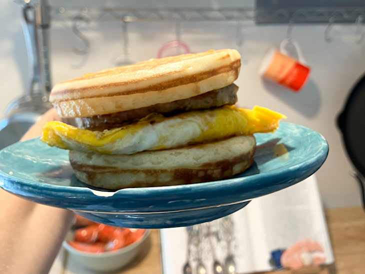 Homemade "McGriddle" sandwich with Trader Joe’s Dutch Griddle Cakes and eggs and sausage on plate