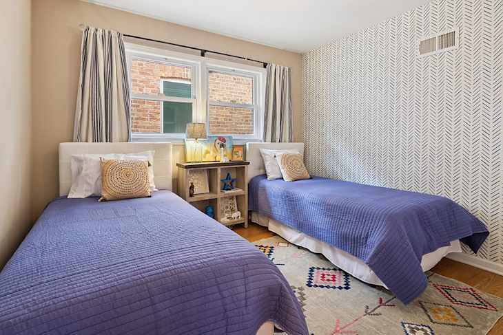Double twin beds in staged bedroom.