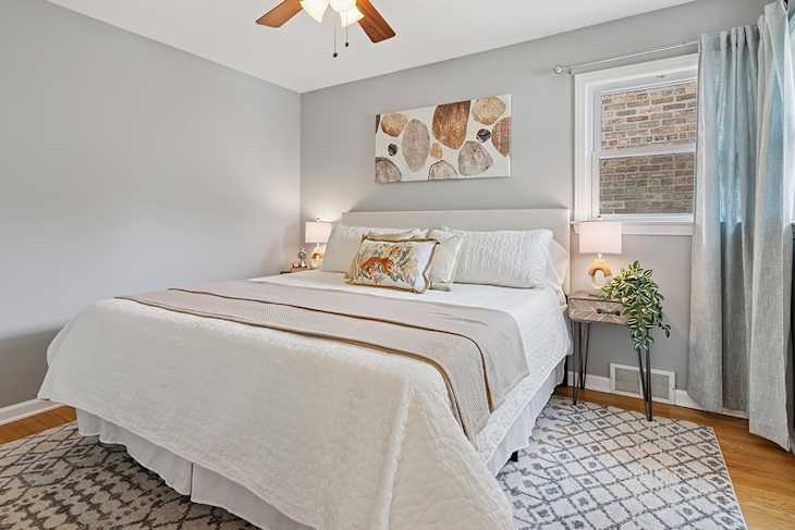 Neatly made bed in staged bedroom.