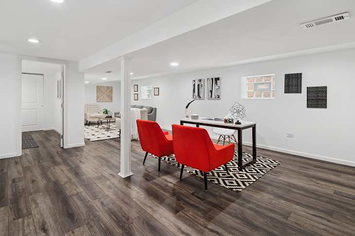 Red chairs beside desk in basement of staged home.
