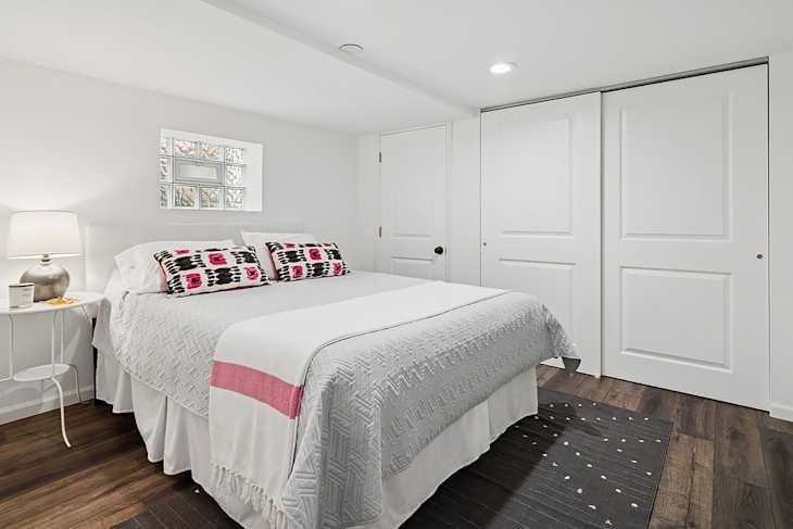 Neatly made bed in staged bedroom.