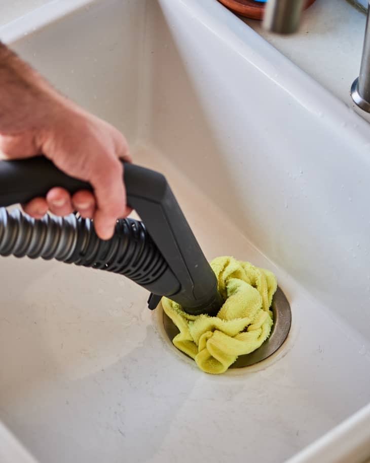 A wet rag is used to form a tight seal around the nozzle of the vacuum