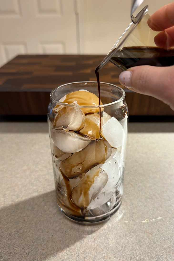 Java House Single-Serve Cold Brew Coffee Pod being poured over ice.