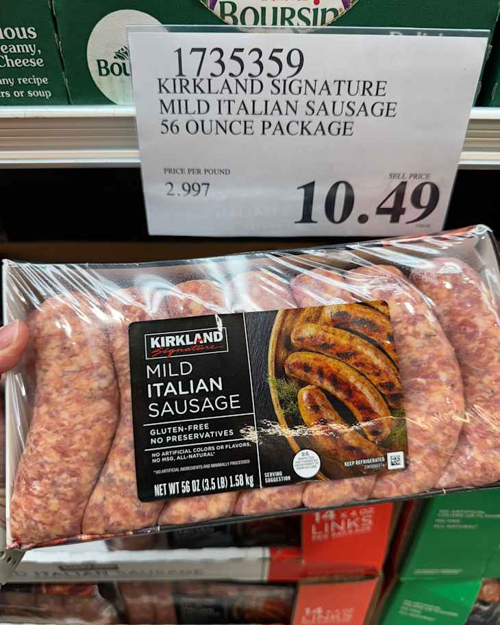 Someone holding package of Italian sausage.
