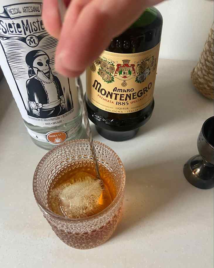 Someone stirring M&M cocktail