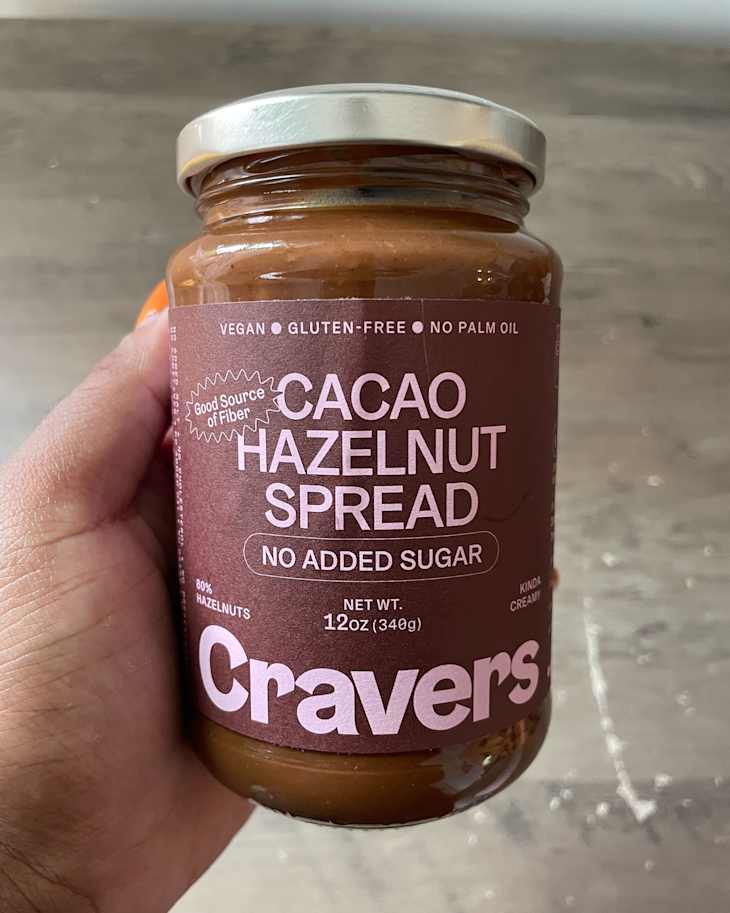 Someone holding jar of Cacao hazelnut spread.