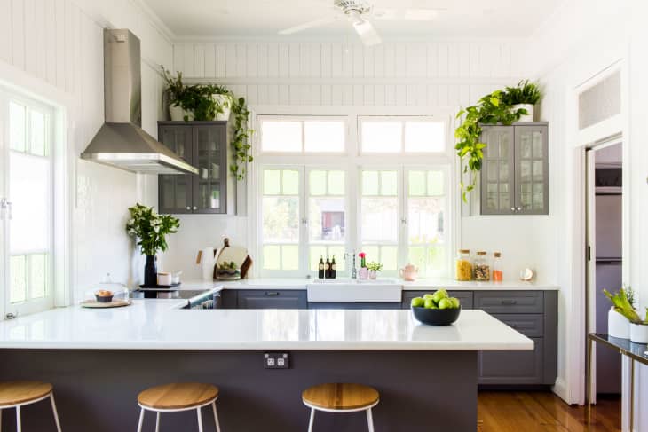 White beadboard in a farmhouse kitchen with dark gray cabinets and white countertops
