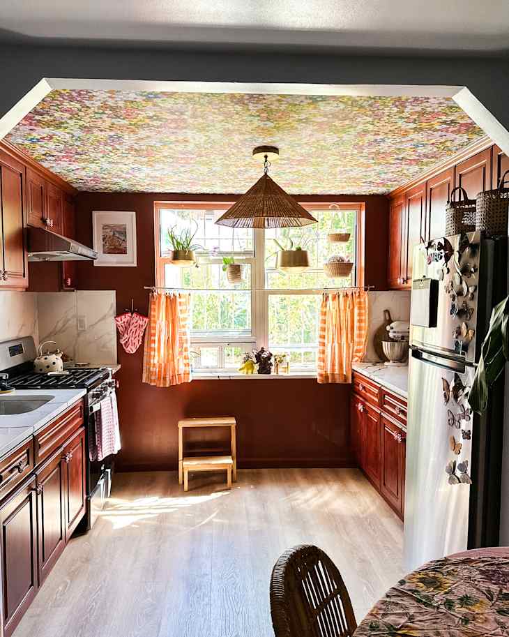 Floral wallpaper on ceiling in colorful kitchen.