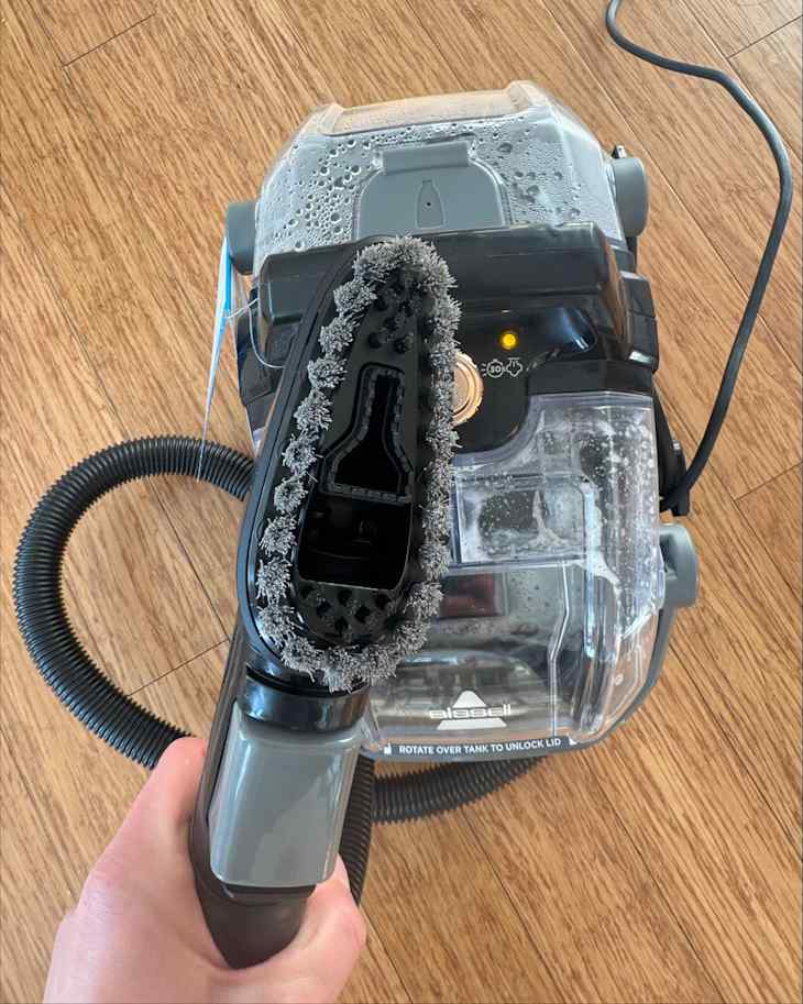 Someone holding Bissell carpet cleaner.