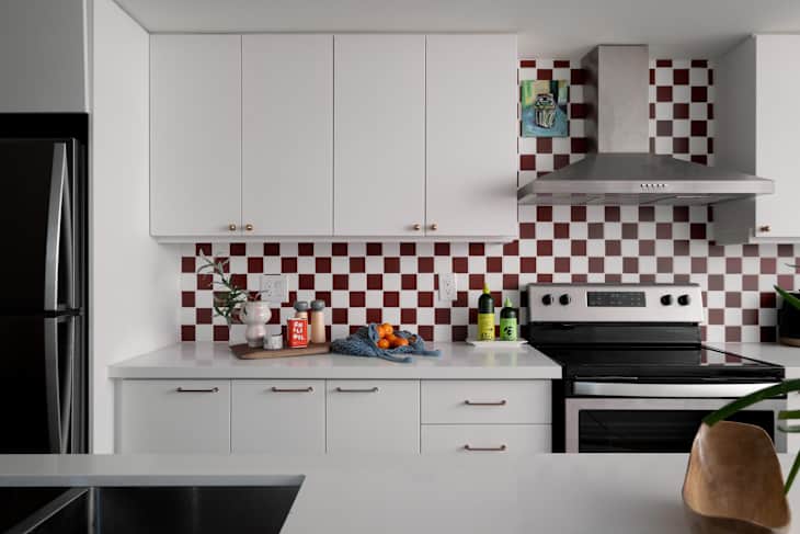 Checkered tile background in newly renovated kitchen with white cabinets.