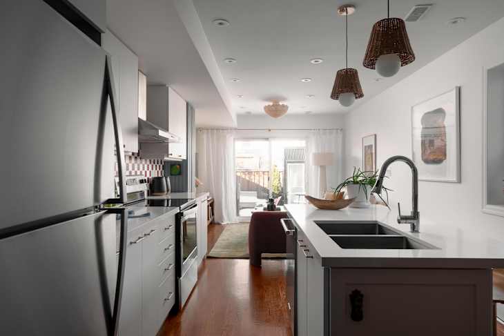 Wicker lighting in newly renovated white living room and kitchen.