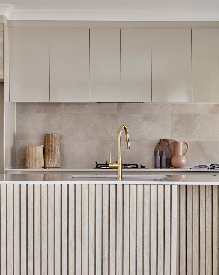 Detail of a contemporary Scandi style kitchen with fluted cabinetry detail in light oak timber.