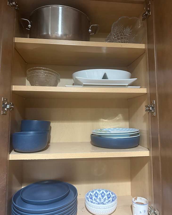 Organized dinnerware in kitchen cabinets.