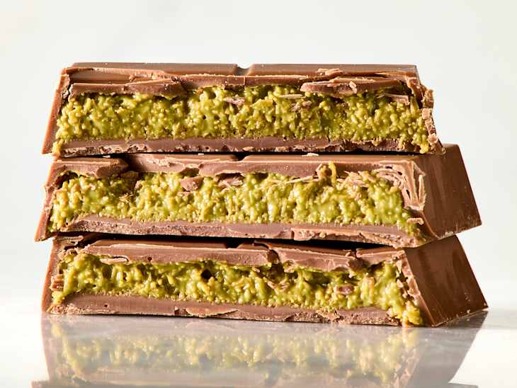 Stack of chocolate bars with a green filling, showcasing layers of chocolate and a textured interior.