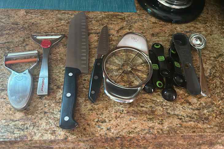 Contents from kitchen drawer on countertop during decluttering.