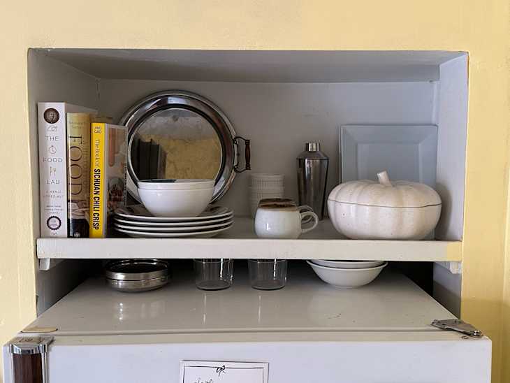 Silver trays in open shelves above kitchen.