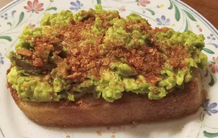 sourdough toast grilled in olive oil and topped with avocado, Maldon sea salt, and paprika