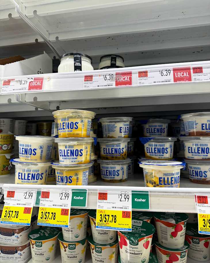 Shelves stocked with various yogurt containers, including Ellenos and 365 brands, with price tags visible.