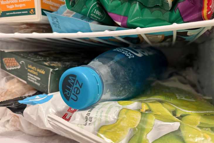 A frozen bottle of water in a fridge.