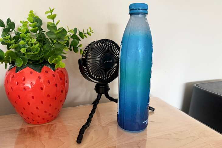 A frozen bottle of water in front of a fan.