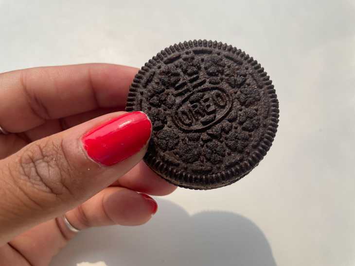 Someone holding Reese's oreo cookie.