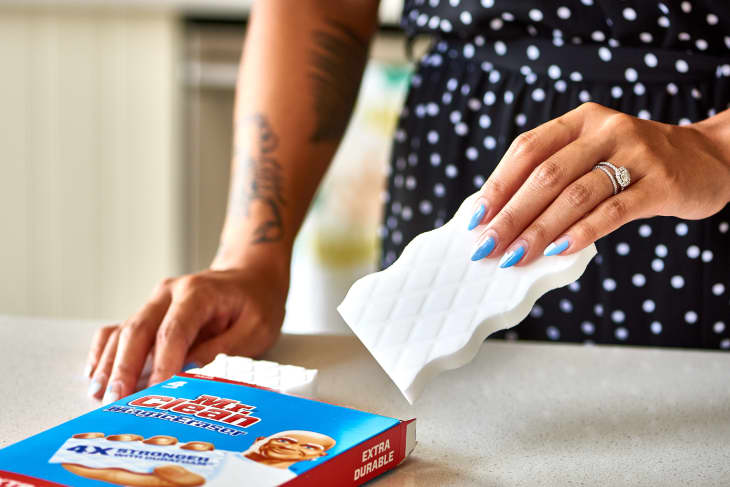 A woman opening a box of Magic Erasers