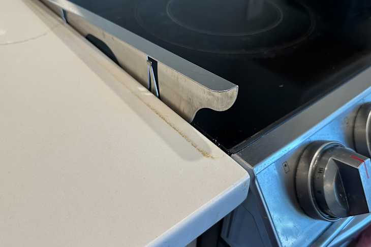 Dirt under stove gap cover pulled out the side of stove.
