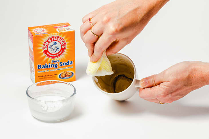 Cleaning out inside of stained coffee mug with baking soda.