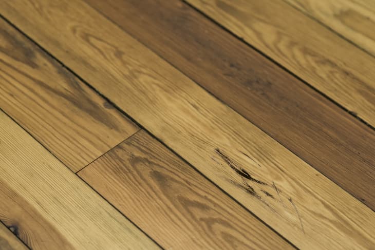 Close-up of natural wood grain on a hardwood floor with visible knots and texture.