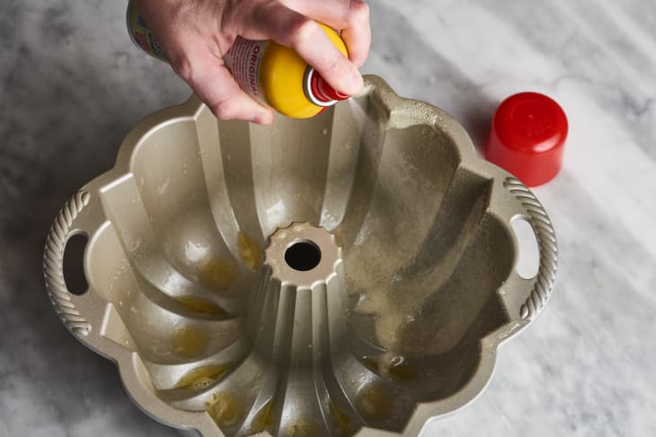 someone spraying non stick pan into bundt cake pan