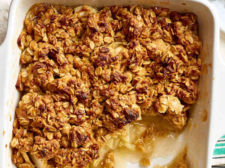 Apple crisp topped with buttery oats in a baking pan