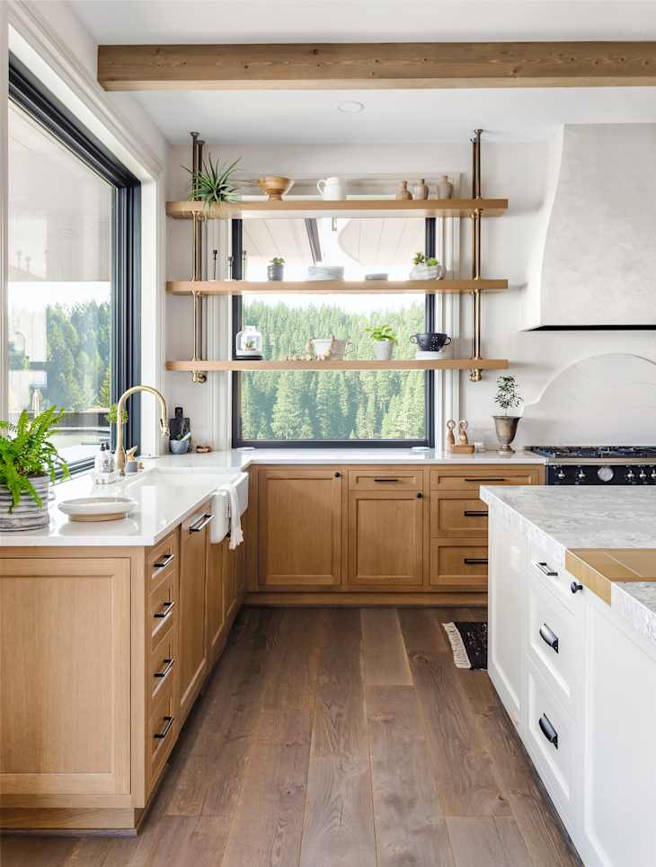 Traditional kitchen detail in new luxury home with farmhouse sink, hardwood floors, wood beams, large island and quartz counters