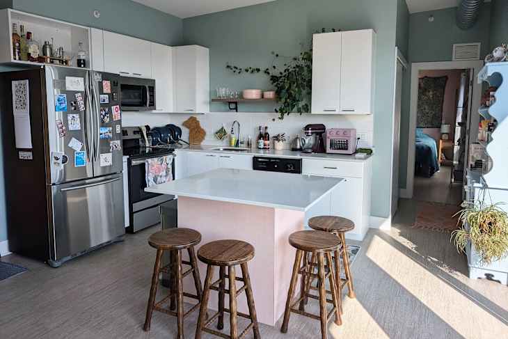 White cabinets in green painted kitchen.